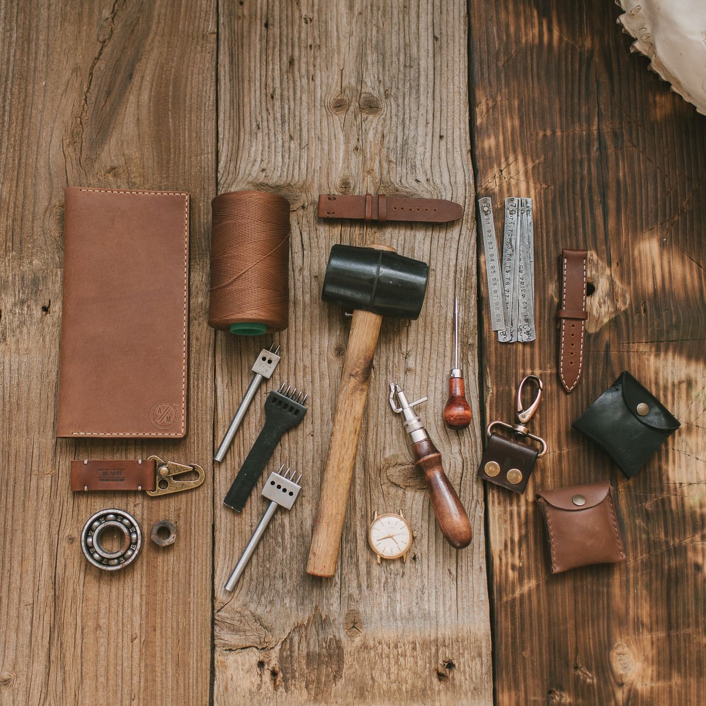 Three handcrafted leather journals in various colours displayed on a rustic wooden table.