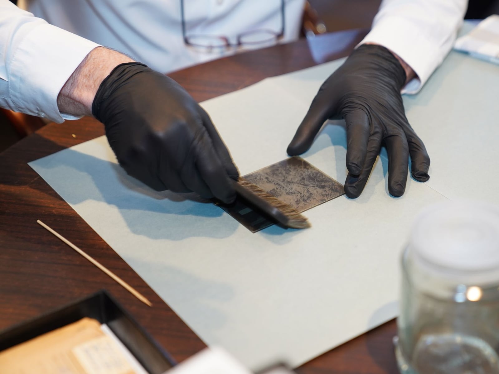 A delicate restoration process of an antique leather book using professional conservation tools.