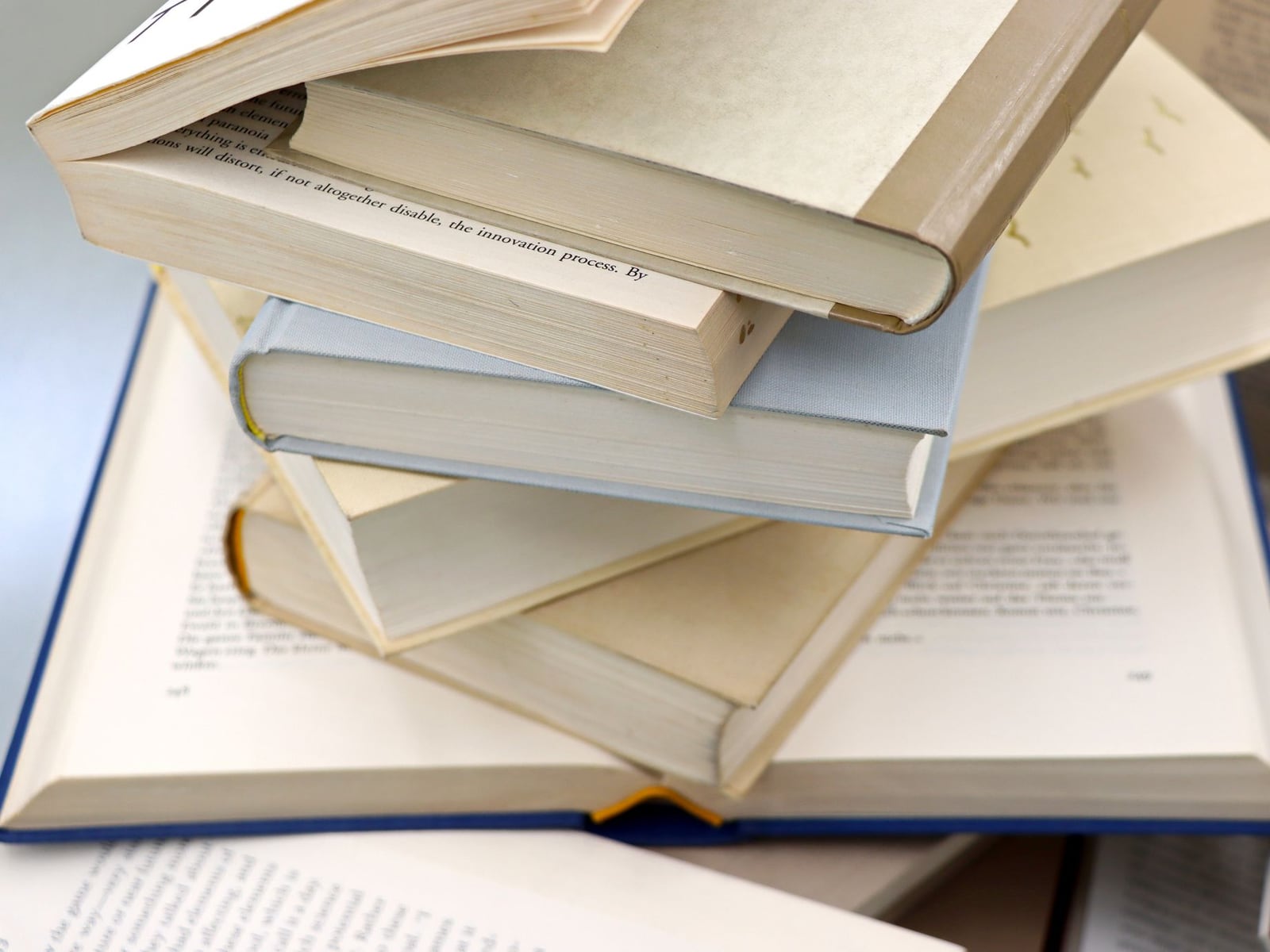 A stack of professionally bound academic theses in high-quality hardcover bindings.
